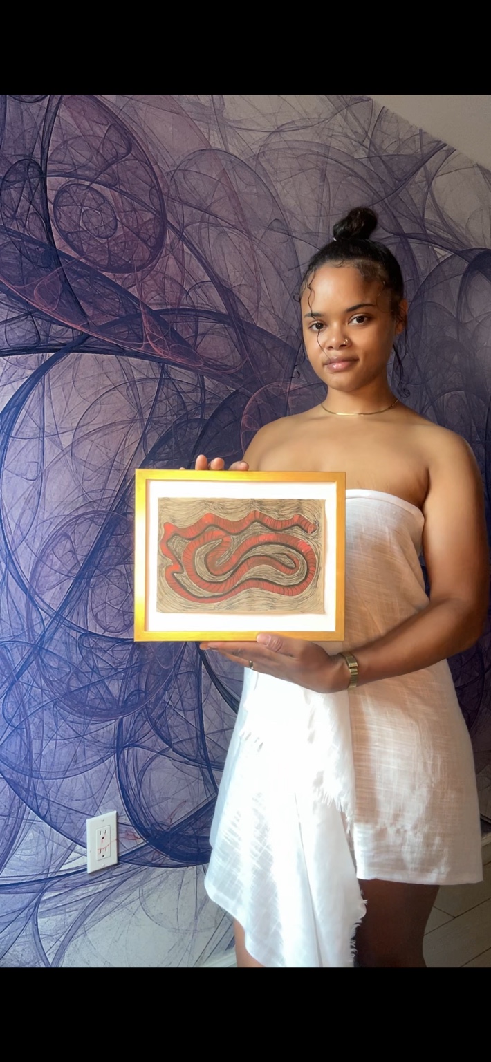 Miss Rey holding a framed red and black original artwork